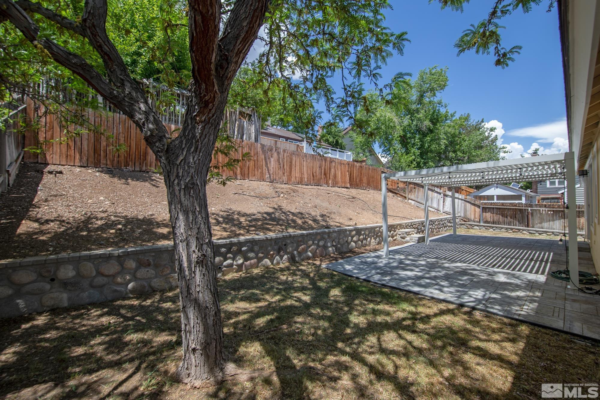 3805 Bexley Square Reno, NV 89503 - Photo 30 of 35 a view of a backyard with large trees and wooden fence