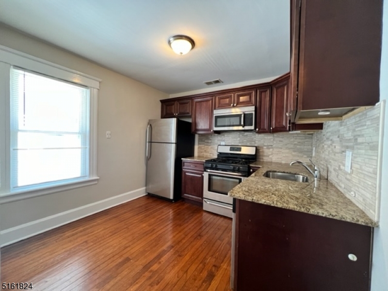 40 Codington Place Somerville, NJ 08876 - Photo 4 of 10 a kitchen with granite countertop wooden floors a stove and a refrigerator