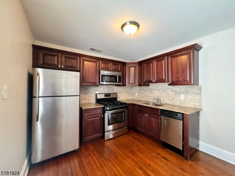 40 Codington Place Somerville, NJ 08876 - Photo 5 of 10 a kitchen with stainless steel appliances granite countertop a refrigerator stove top oven and cabinets
