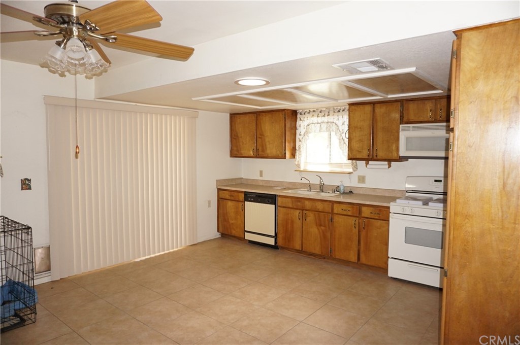27841 Crestview Road Barstow, CA 92311 - Photo 12 of 28 a large kitchen with granite countertop a sink stainless steel appliances and cabinets