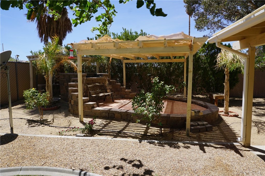 27841 Crestview Road Barstow, CA 92311 - Photo 22 of 28 a view of a patio with table and chairs potted plants and palm tree