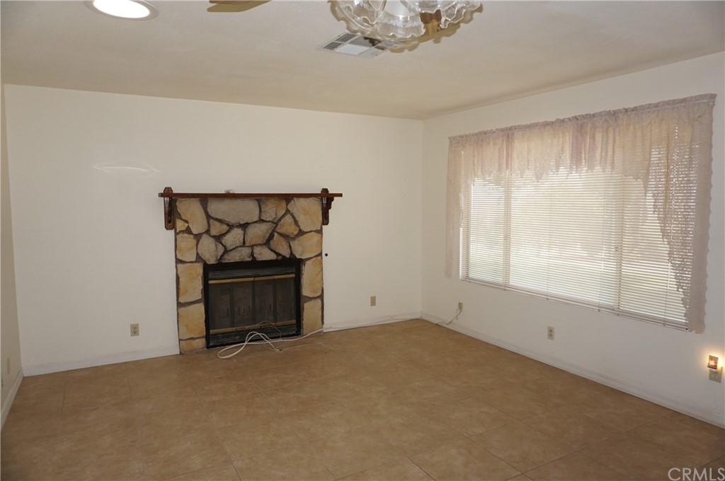 27841 Crestview Road Barstow, CA 92311 - Photo 3 of 28 a view of an empty room with a window and fireplace