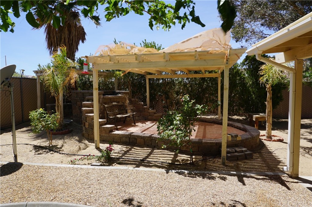 27841 Crestview Road Barstow, CA 92311 - Photo 4 of 28 a view of a patio with table and chairs potted plants and palm tree