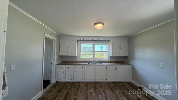 a kitchen with granite countertop a sink and cabinets