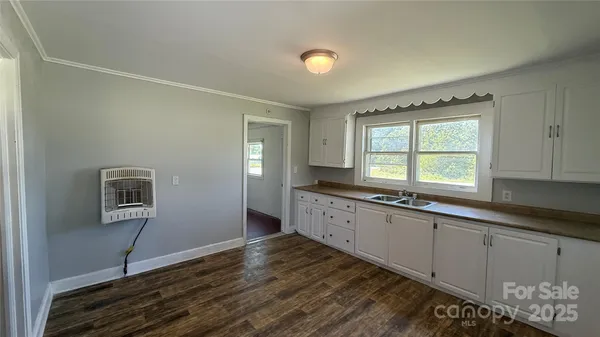a kitchen with granite countertop a stove a sink and a window
