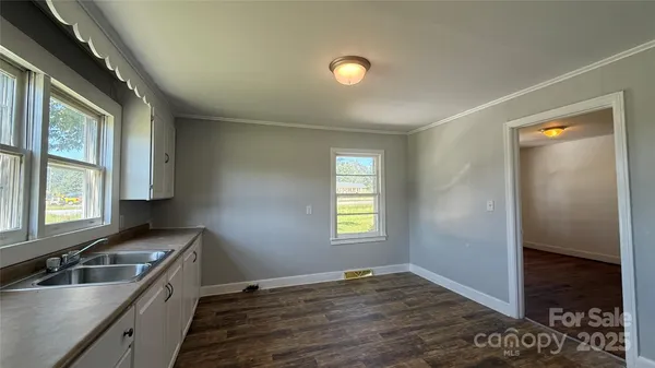 a kitchen with a sink and wooden floor