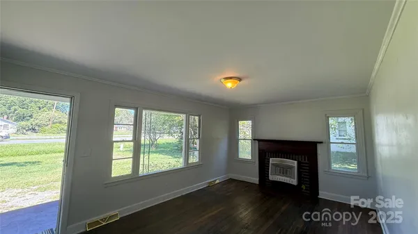 a view of an empty room with a fireplace and a window