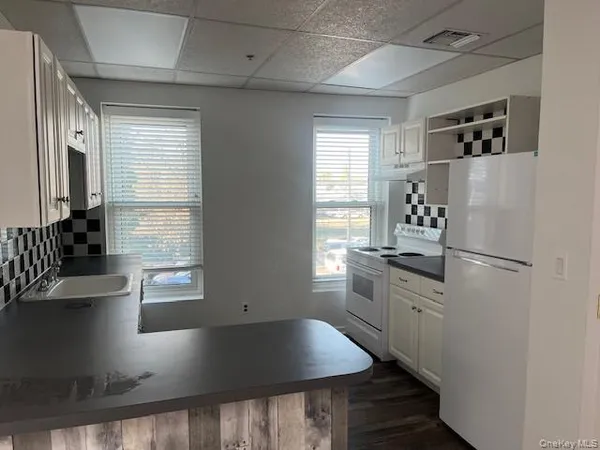 a kitchen with stainless steel appliances granite countertop a sink a stove and a refrigerator