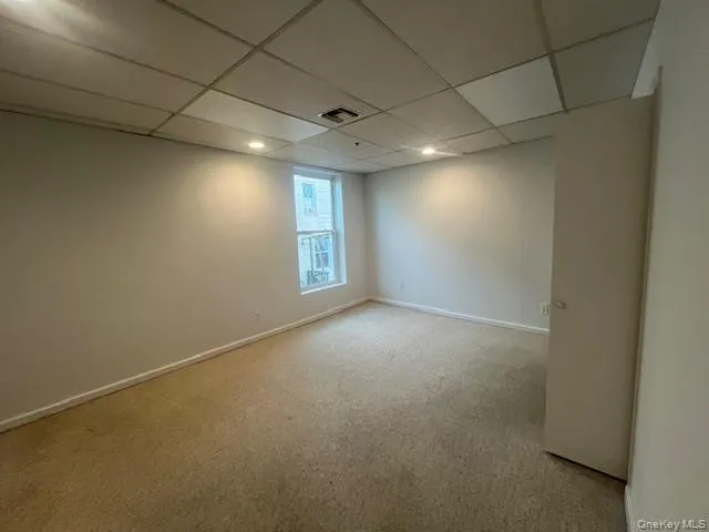 an empty room with windows and chandelier fan