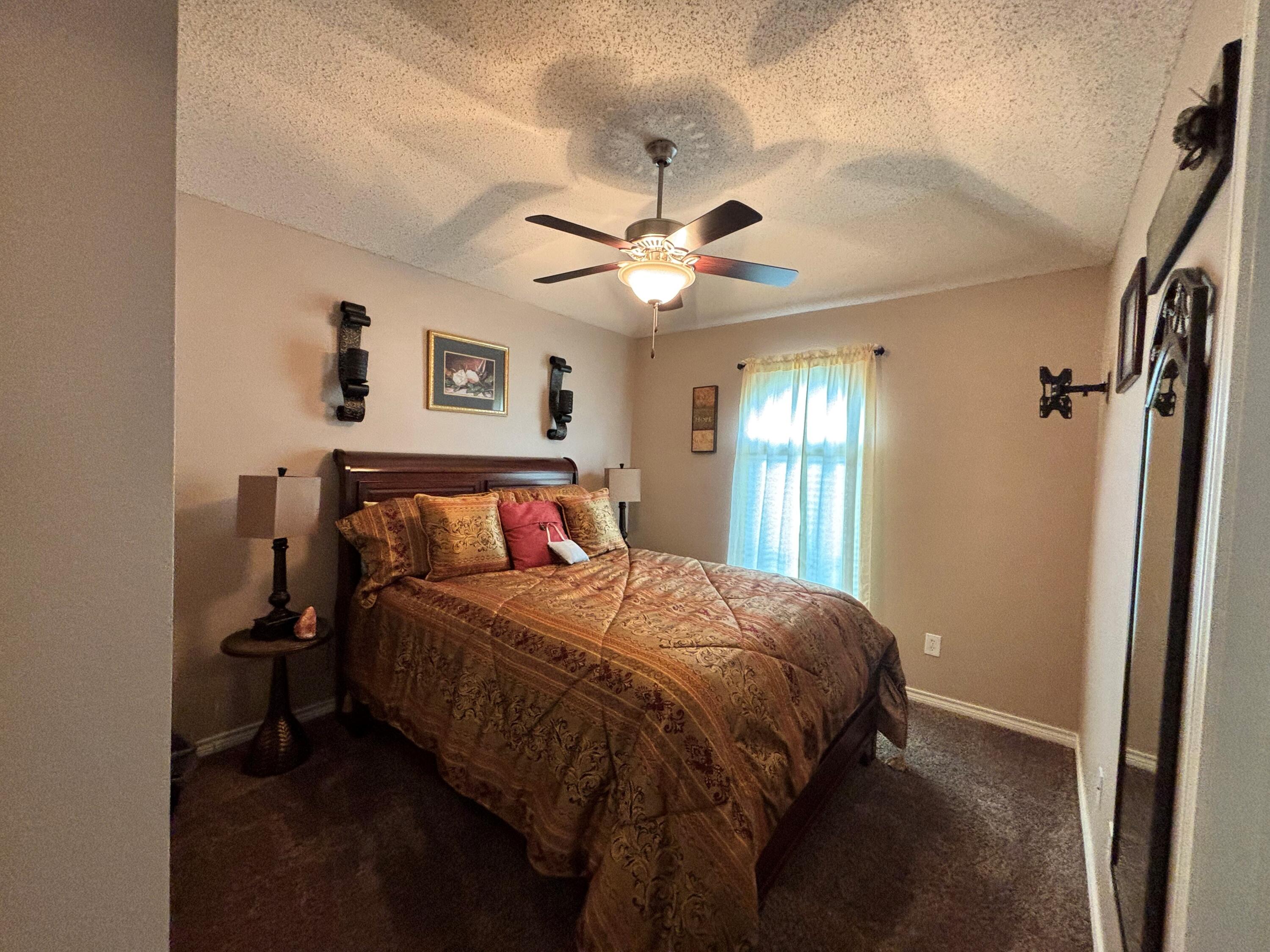 3713 106th Street Lubbock, TX 79423 - Photo 16 of 22 a bedroom with a bed and a ceiling fan