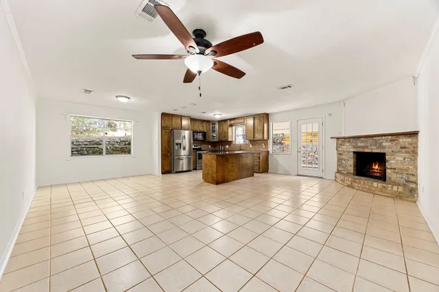 a kitchen with stainless steel appliances granite countertop a sink a stove a microwave and wooden cabinets