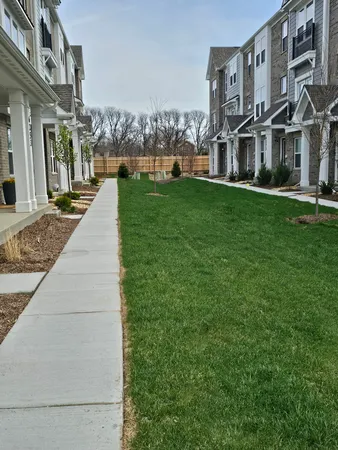 a view of a big building with a big yard and large trees