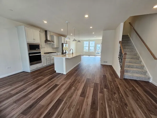 a kitchen with wooden floors and white stainless steel appliances