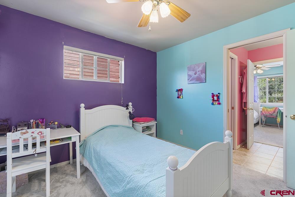 332 Jenkins Ranch Road Durango, CO 81301 - Photo 20 of 34 a bedroom with a bed and a chandelier