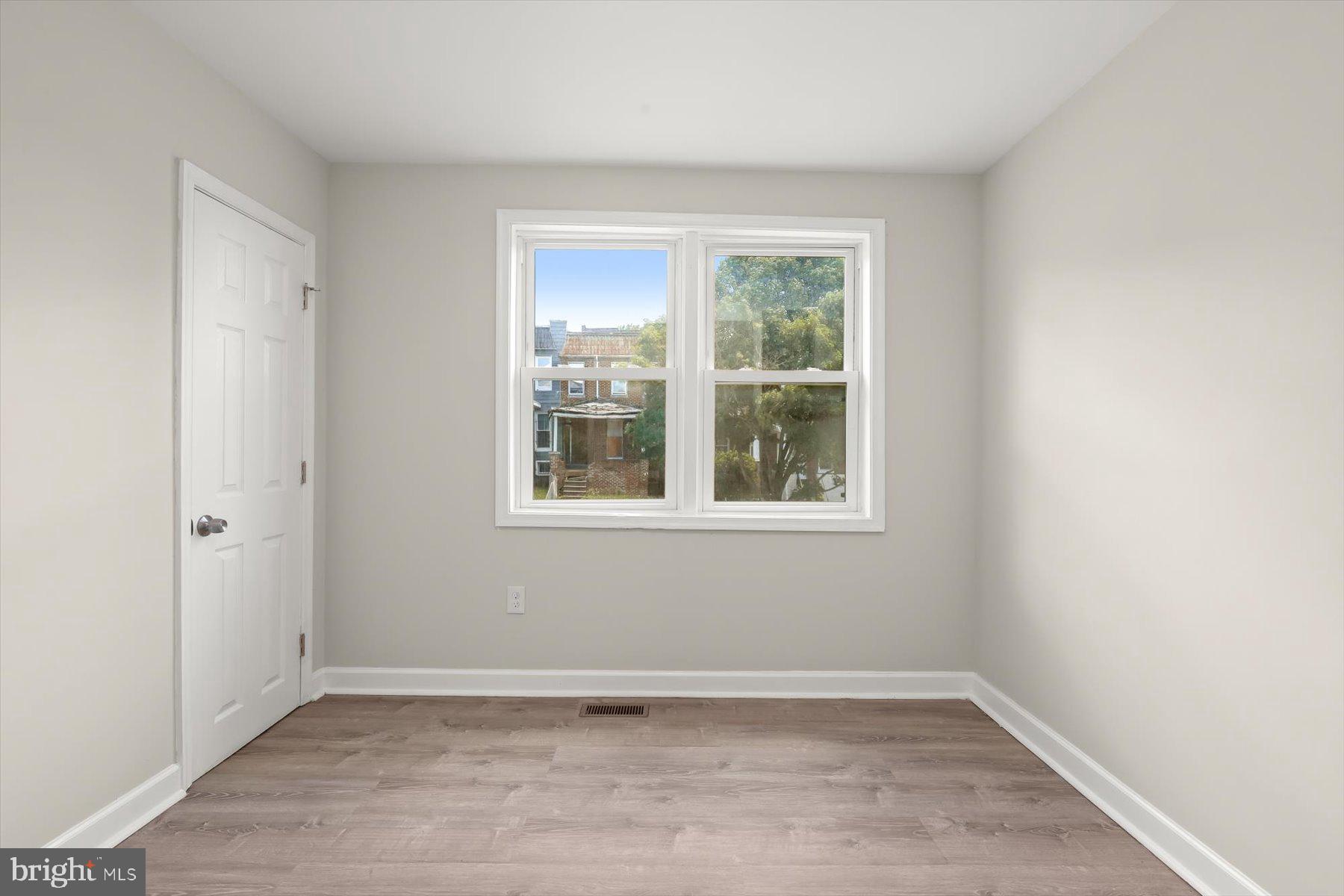 1044 Ellicott Driveway Baltimore, MD 21216 - Photo 14 of 26 an empty room with wooden floor and windows