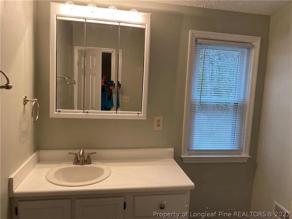 1734 Rim Road Fayetteville, NC 28314 - Photo 20 of 24 a bathroom with a sink and a mirror