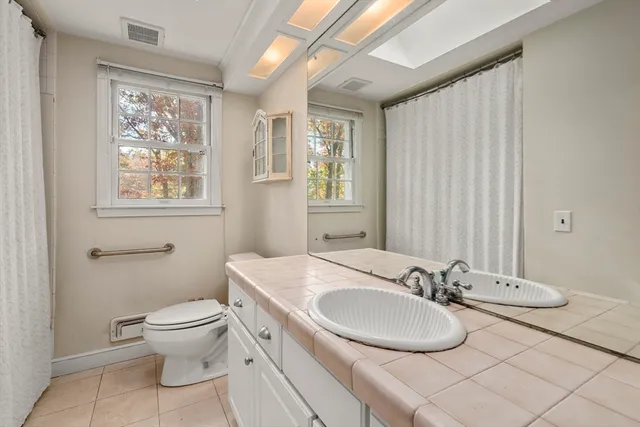 a bathroom with a granite countertop sink toilet and a mirror