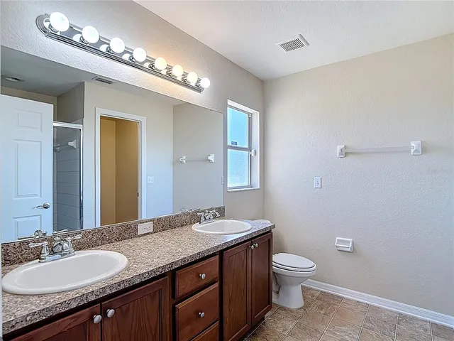 a bathroom with a glass shower door and a bathroom sink