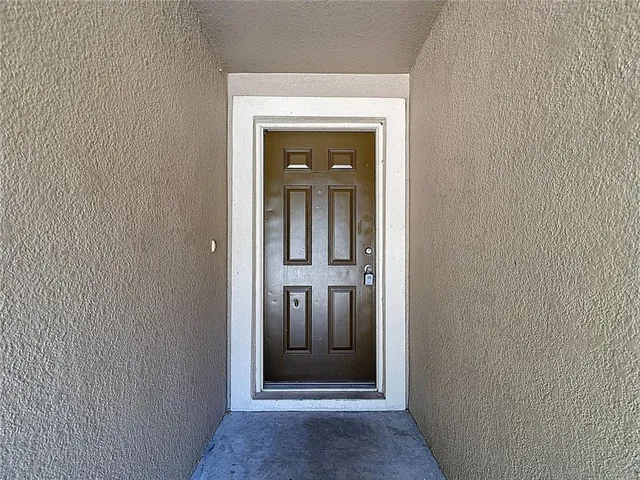 a view of an empty room with wooden floor and a ceiling fan