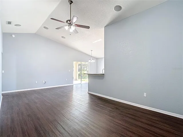 a view of a kitchen with a kitchen island wooden floor and a ceiling fan