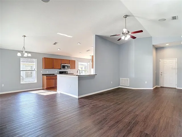 a view of a livingroom with a ceiling fan and wooden floor