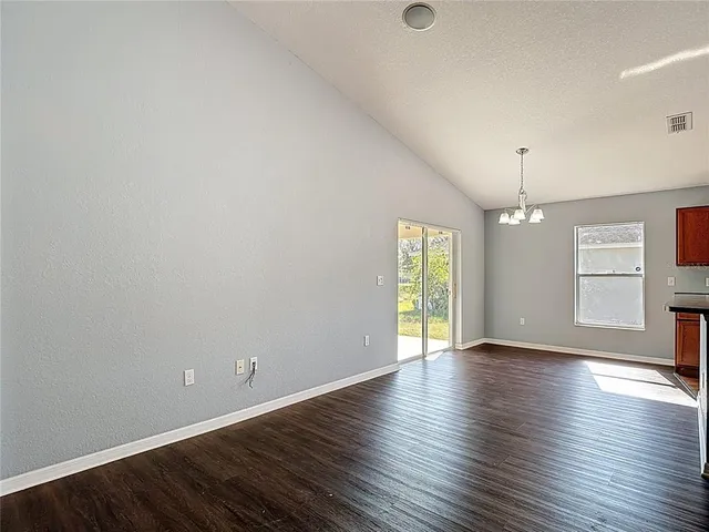 a kitchen with stainless steel appliances granite countertop a refrigerator a sink dishwasher a kitchen island with wooden floor and cabinets