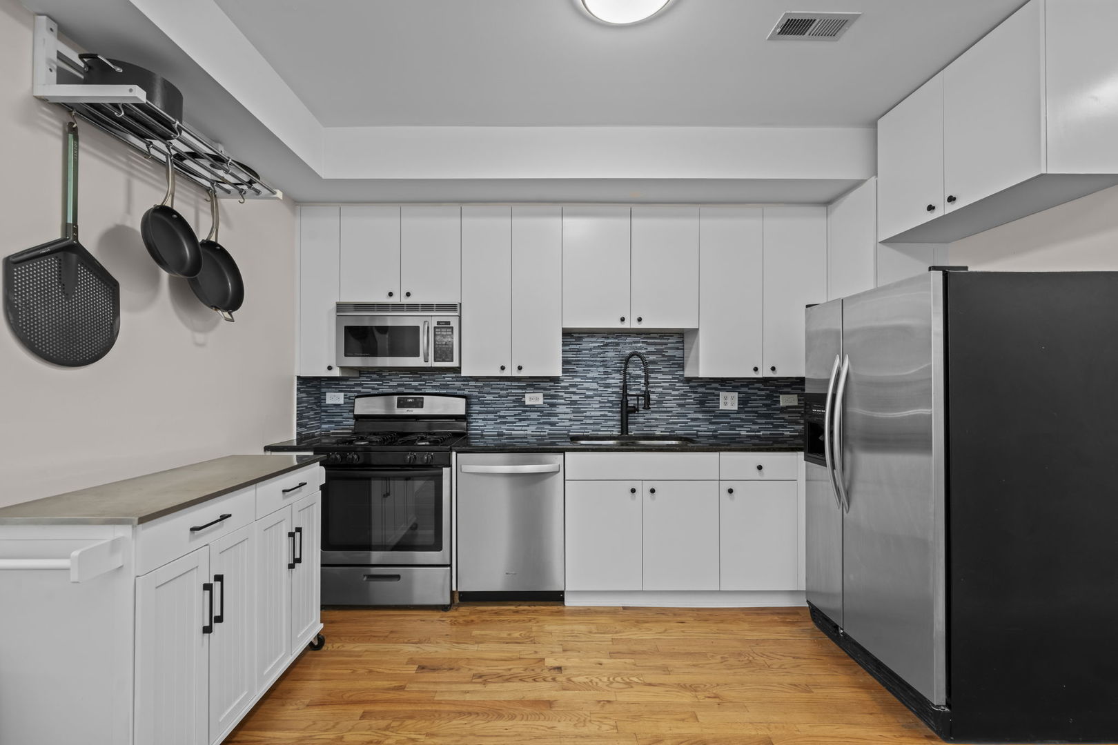 2710 West Haddon Avenue, Unit 2 Chicago, IL 60622 - Photo 4 of 11 a kitchen with stainless steel appliances granite countertop a refrigerator a stove top oven a sink and dishwasher with wooden floor
