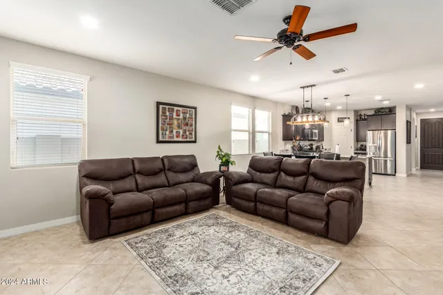 a living room with furniture and a ceiling fan