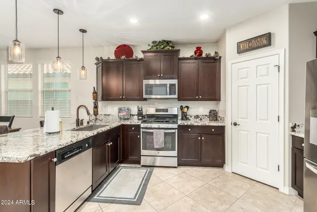 a kitchen with stainless steel appliances granite countertop a sink and a refrigerator