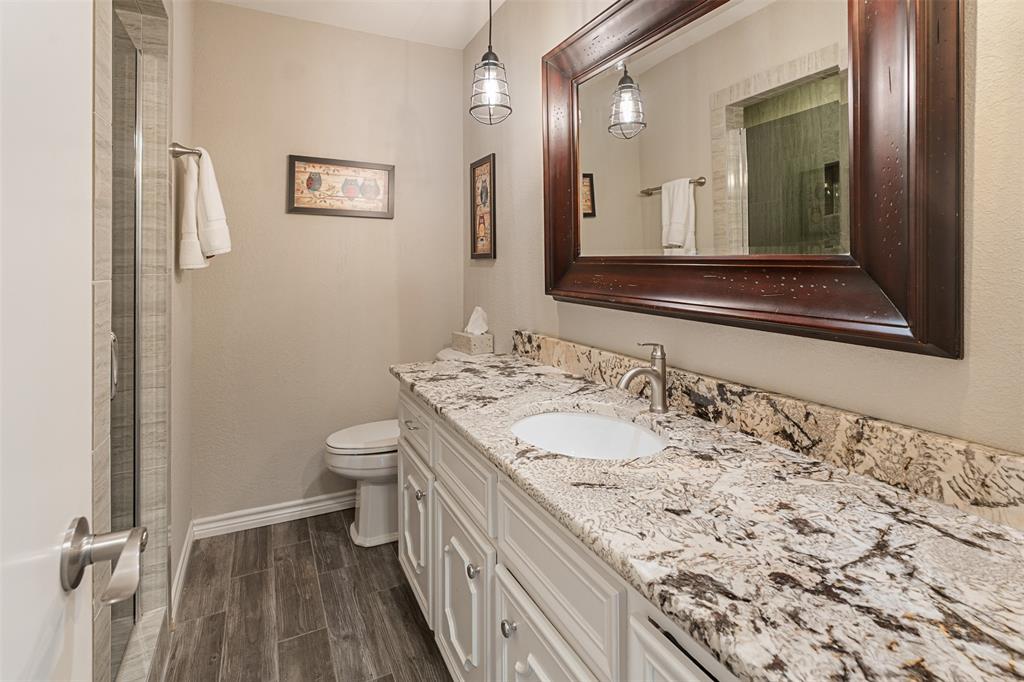 1102 Mill Run Road Athens, TX 75751 - Photo 24 of 35 a bathroom with a granite countertop sink a large mirror and a toilet