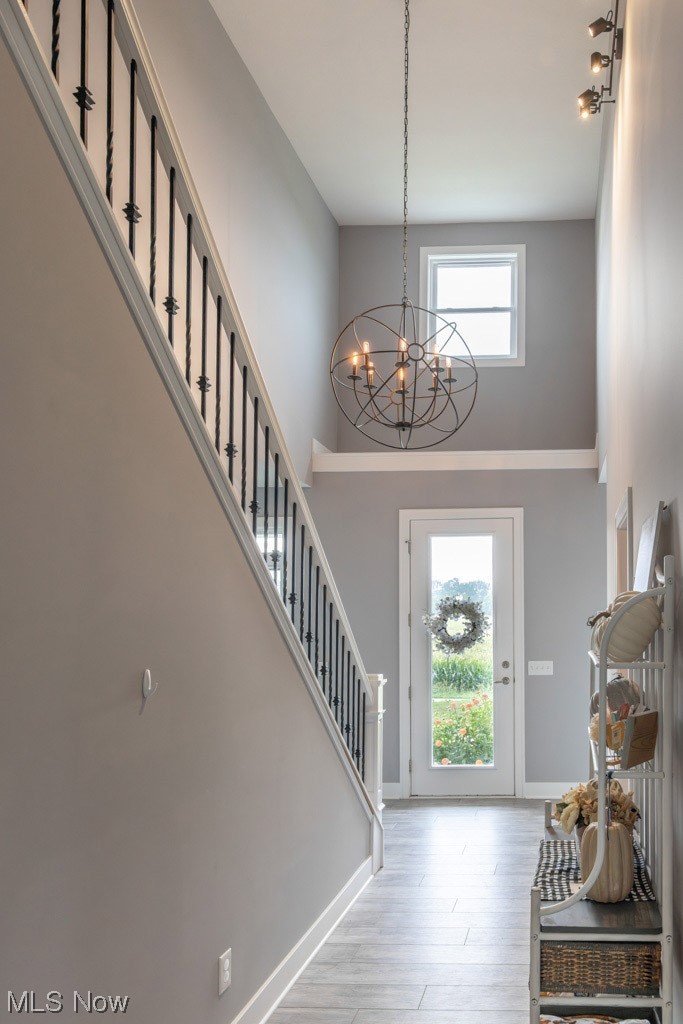 8341 Ickes Road Wooster, OH 44691 - Photo 11 of 34 Entrance foyer with rail lighting, an inviting chandelier, a towering ceiling, and light hardwood floors