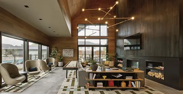a living room with furniture fireplace and large windows