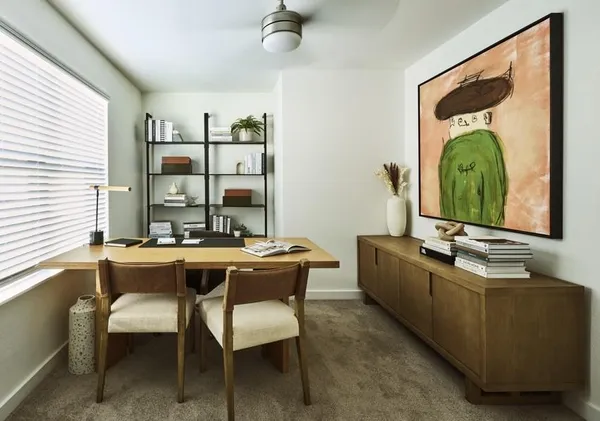 a room with a table chairs and a large window