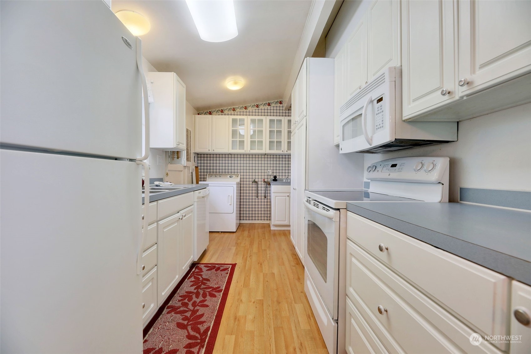 225 76th Street Southwest Everett, WA 98203 - Photo 3 of 26 a kitchen with white cabinets and white appliances