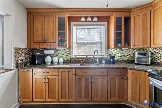 a kitchen with granite countertop wooden cabinets a sink and a window