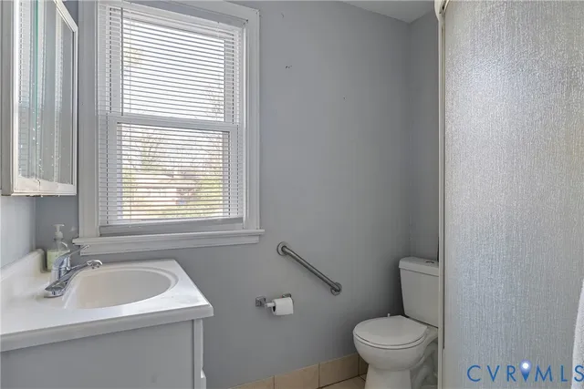 a bathroom with a sink a toilet and a window