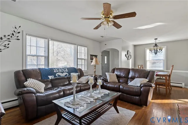a living room with furniture a ceiling fan a flat screen tv and a window