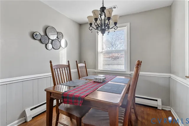 a view of a dining room with furniture a chandelier and wooden floor