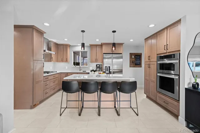 a kitchen with stainless steel appliances kitchen island a table and chairs in it