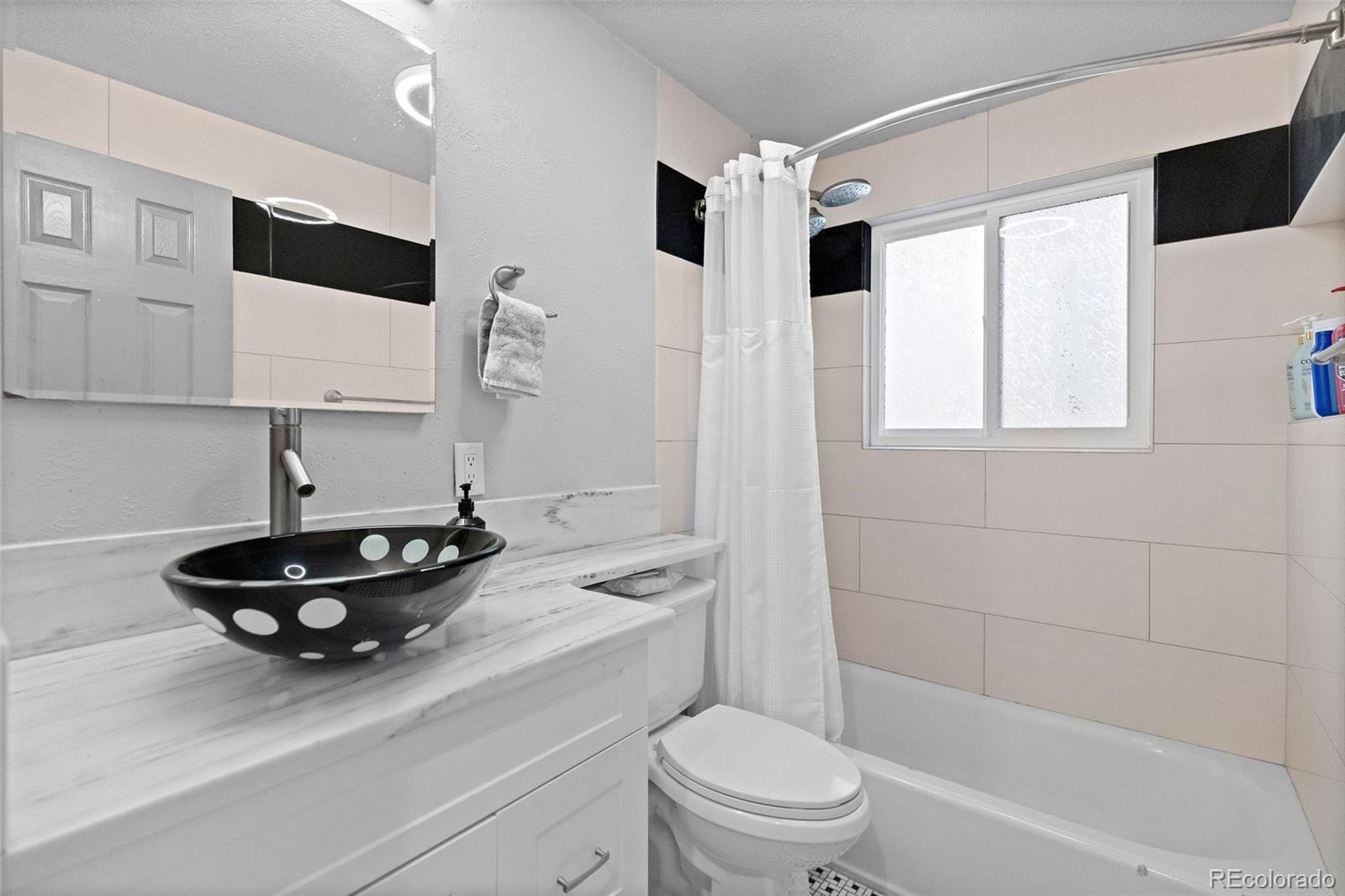 642 South Racine Street Aurora, CO 80012 - Photo 21 of 36 a bathroom with a toilet a sink and a bathtub