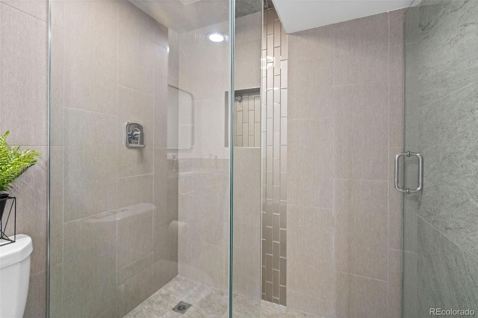 642 South Racine Street Aurora, CO 80012 - Photo 28 of 36 a bathroom with a shower and a toilet