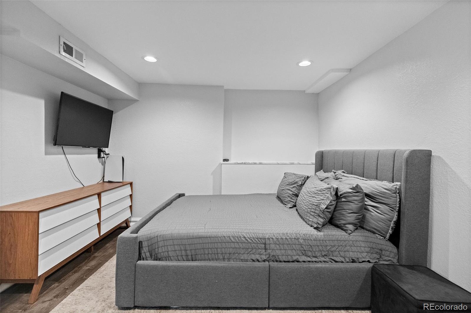 642 South Racine Street Aurora, CO 80012 - Photo 29 of 36 a bedroom with a bed and a flat screen tv