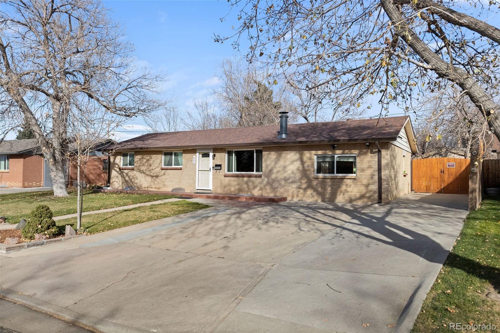 642 South Racine Street Aurora, CO 80012 - Photo 3 of 36 a view of a house with large trees next to a road