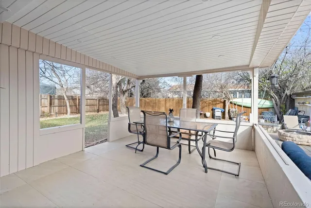 a dining room with furniture and large windows