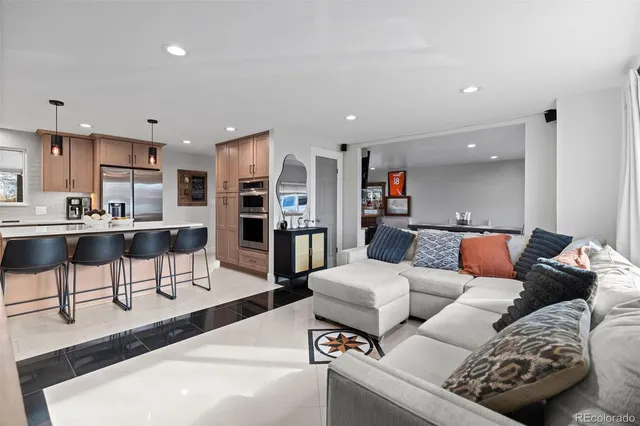 a living room with furniture and a view of kitchen