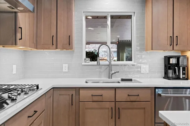 a kitchen with stainless steel appliances granite countertop a sink stove and cabinets