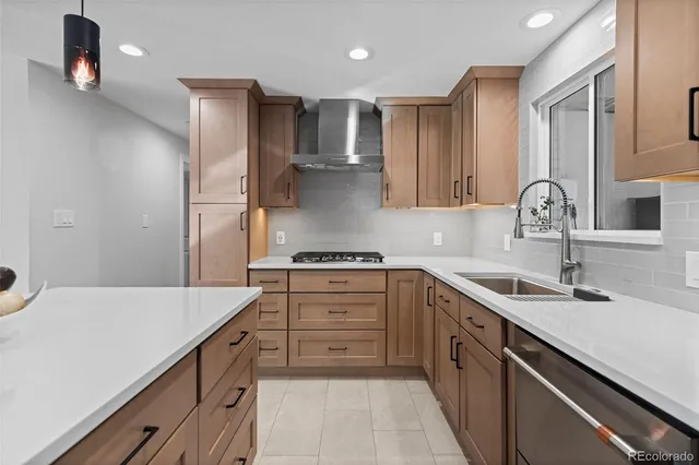 a kitchen with a sink dishwasher a stove and a refrigerator with wooden floor