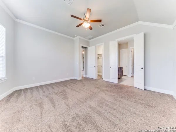 an empty room with ceiling fan and window