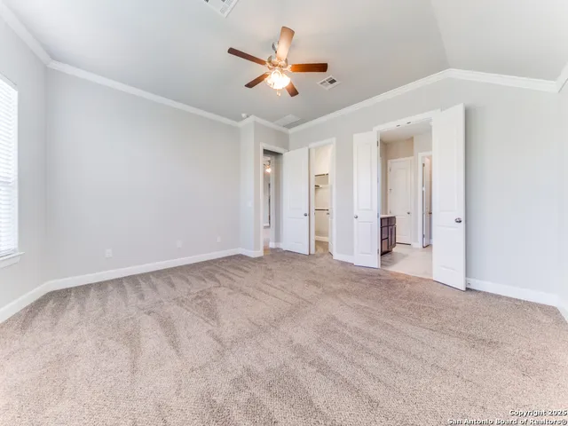 an empty room with ceiling fan and window