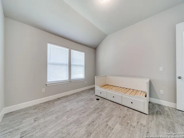 an empty room with a window and a wooden floor